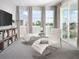 A cozy bedroom featuring two white lounge chairs, a slider to a balcony, neutral walls, and plush carpeting at 16420 Silver Grove Blvd, Winter Garden, FL 34787