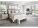 A serene main bedroom featuring a large bed, side tables with lamps, a bench, and an adjacent sitting area at 16420 Silver Grove Blvd, Winter Garden, FL 34787