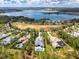 Aerial shot of a lakeside community, highlighting sprawling residences surrounded by lush trees and a serene lake backdrop at 17038 Medici Way, Bella Collina, FL 34756