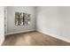 Neutral bedroom with wood floors, white trim, and large window at 17038 Medici Way, Bella Collina, FL 34756