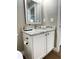 Compact bathroom featuring granite countertops, a framed mirror, modern fixtures, and white cabinets at 1714 Sherbourne St, Winter Garden, FL 34787