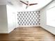 Bright bedroom featuring a decorative accent wall, wood-look floors, and a modern ceiling fan at 1714 Sherbourne St, Winter Garden, FL 34787