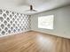 Spacious bedroom with wood floors, a ceiling fan, and decorative accent wall at 1714 Sherbourne St, Winter Garden, FL 34787