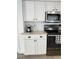 Close up of kitchen featuring white cabinets, stainless steel microwave, black range, and granite countertops at 1714 Sherbourne St, Winter Garden, FL 34787