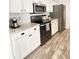 Kitchen view featuring white cabinets, stainless steel appliances, granite countertops, and wood-look tile flooring at 1714 Sherbourne St, Winter Garden, FL 34787