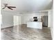 Open-concept layout with tile floors connecting the living space to the kitchen, features white cabinetry and stainless-steel appliances at 1714 Sherbourne St, Winter Garden, FL 34787