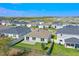 An aerial view of the backyard features a well manicured lawn, patio, and fenced perimeter at 1744 Wilson Prairie Cir, Groveland, FL 34736