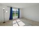 Sunny bedroom with a view of the green yard through the window with blue drapes at 1744 Wilson Prairie Cir, Groveland, FL 34736