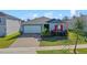 Charming single Gathering home with a brick driveway, tidy landscaping and bright red shutters at 1744 Wilson Prairie Cir, Groveland, FL 34736