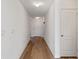 Bright hallway with wood floors leading to a door at the end at 1744 Wilson Prairie Cir, Groveland, FL 34736