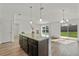 Granite countertop island with pendant lighting in an open-concept living area at 1744 Wilson Prairie Cir, Groveland, FL 34736