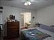 Bedroom featuring wood floors, a queen-size bed, and a view into the on-suite bathroom at 1912 Cattleya Dr # 1912, Kissimmee, FL 34741