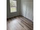 Bedroom with wood-look flooring, closet with white paneled doors, and a view from the bright window at 1926 Sw 160Th Sw Pl # 03, Ocala, FL 34470