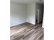 Minimalist bedroom featuring wood-look flooring, baseboard trim, and an open doorway to an adjacent room at 1926 Sw 160Th Sw Pl # 03, Ocala, FL 34470