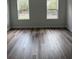 Well-lit bedroom with wood-look flooring and two bright windows enhancing the space at 1926 Sw 160Th Sw Pl # 03, Ocala, FL 34470