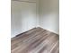 Bright bedroom with wood-look flooring and a closet with white paneled doors for ample storage at 1926 Sw 160Th Sw Pl # 03, Ocala, FL 34470