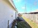 The backyard features a weathered fence, overgrown vegetation, and a view of nearby power lines at 2452 Atrium Cir, Orlando, FL 32808