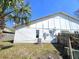 An exterior view of the home features the back of the house with white siding and an air conditioning unit at 2452 Atrium Cir, Orlando, FL 32808