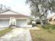 Front exterior of home with garage and well-manicured lawn featuring mature tree at 2452 Atrium Cir, Orlando, FL 32808