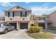 Exterior view of townhome featuring well-maintained landscaping, multiple garages, and neutral paint at 2913 Ashford Park Pl, Oviedo, FL 32765