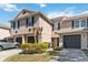 Exterior of the townhome featuring a well manicured yard, garages, and neutral paint at 2913 Ashford Park Pl, Oviedo, FL 32765