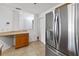 A kitchen with a modern stainless steel refrigerator and light-colored tile flooring at 2913 Ashford Park Pl, Oviedo, FL 32765