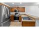 Well-lit kitchen features stainless steel appliances, wooden cabinetry, and tile flooring at 2913 Ashford Park Pl, Oviedo, FL 32765