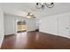 Bright living room features wood flooring, fan, sliding glass door, and a door to the stairway at 2913 Ashford Park Pl, Oviedo, FL 32765