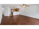 Open-concept living area featuring wood floors, a view into the kitchen, and a ceiling fan at 2913 Ashford Park Pl, Oviedo, FL 32765