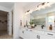 Bright bathroom with double vanity, large mirror, modern lighting, and white cabinetry at 3235 Legends Preserve Dr, Daytona Beach, FL 32124