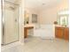 Bright bathroom features a glass-enclosed shower, soaking tub, and dual vanities for a spa-like experience at 324 Lusitano Way, Sanford, FL 32773