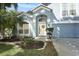 Beautiful home exterior with an arched entryway, white trim and lovely front yard landscaping at 324 Lusitano Way, Sanford, FL 32773