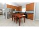 An eat-in kitchen featuring stainless steel appliances, wood cabinetry, tile floors, and grey countertops at 324 Lusitano Way, Sanford, FL 32773