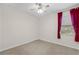 Bedroom with a ceiling fan and bright red curtains over the window at 3618 Solana Cir, Clermont, FL 34711