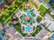 Aerial view of community pool area, a playground, with winding lazy river and palm trees at 3653 Calabria Ave, Davenport, FL 33897