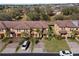 A scenic aerial view of a neighborhood showcasing well-maintained townhomes with lush greenery and mature trees at 3653 Calabria Ave, Davenport, FL 33897