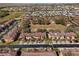 Expansive aerial view of townhomes in a community with trees, landscaping, and a central green space at 3653 Calabria Ave, Davenport, FL 33897