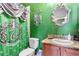 The Slytherin themed bathroom with a toilet, sink, and green shower curtain at 3653 Calabria Ave, Davenport, FL 33897