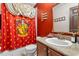 Bathroom with a Gryffindor-themed shower curtain, vanity, and gold-framed mirror at 3653 Calabria Ave, Davenport, FL 33897