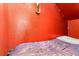 Small bedroom with red walls, string lights, and a bed with colorful tribal-themed bedding at 3653 Calabria Ave, Davenport, FL 33897