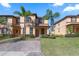 Inviting townhome with lush landscaping, palm trees, and a brick walkway leading to the front entrance at 3653 Calabria Ave, Davenport, FL 33897