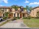 Inviting townhome with lush landscaping, palm trees, and a brick walkway leading to the front entrance at 3653 Calabria Ave, Davenport, FL 33897