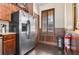 Kitchen area with stainless steel refrigerator, granite countertops, dark wood cabinets and hardwood floors at 3653 Calabria Ave, Davenport, FL 33897