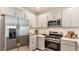 Stylish kitchen featuring stainless steel appliances, gray cabinetry, and modern countertops at 366 Wayland Dr, Haines City, FL 33844