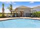 Community pool with lounge seating, umbrellas, and a nearby shaded outdoor dining area at 366 Wayland Dr, Haines City, FL 33844