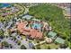 Aerial view of a community clubhouse featuring a large pool, tennis courts, ample parking, and lush landscaping at 3704 Via Monte Napoleone Dr, Poinciana, FL 34759