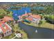 Aerial view of lakeside community clubhouse with tile roofs, a walking bridge, and resort-style pool at 3704 Via Monte Napoleone Dr, Poinciana, FL 34759