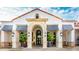 Elegant building entrance featuring a decorative archway, striped awnings, and potted plants at 3704 Via Monte Napoleone Dr, Poinciana, FL 34759