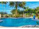 Resort-style pool with palm trees, pergola-covered seating, and clear blue water at 3704 Via Monte Napoleone Dr, Poinciana, FL 34759