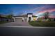 Beautiful single-story home with barrel tile roof, brick paver driveway, and manicured lawn at dusk at 3704 Via Monte Napoleone Dr, Poinciana, FL 34759